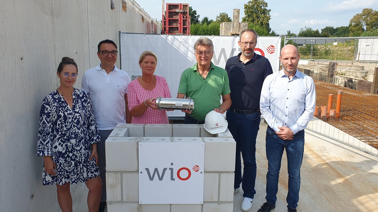 Eine Zeitkapsel im WiO-Neubau im Osnabrücker Landwehrviertel versenkten jetzt (v.l.n.r.) Lena-Marie Berg (Leiterin WiO-Immobilienmanagement), Wigand Maethner (WiO-Geschäftsführer), Susanne Hambürger dos Reis (WiO-Aufsichtsratsvorsitzende), Dr. E.h. Fritz Brickwedde (Stellvertr. WiO-Aufsichtsratsvorsitzender), Holger Clodius (WiO-Geschäftsführer) und Marco Lange (Leiter Immobilienentwicklung).